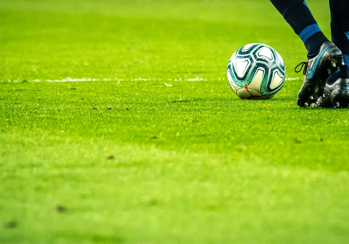 Bola de futebol no gramado, pronta para o chute